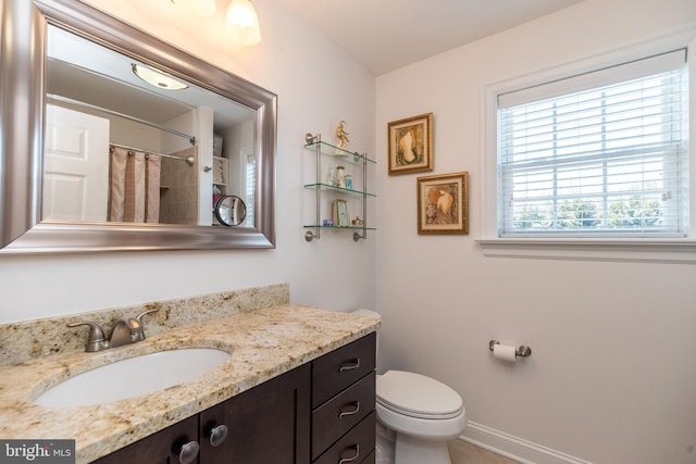 bathroom with toilet, vanity, and a shower with shower curtain