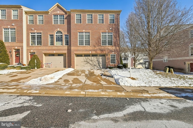 view of front facade with driveway, brick siding, and an attached garage