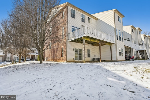 snow covered property with central AC