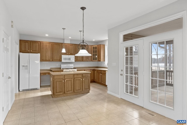 kitchen featuring hanging light fixtures, white appliances, light tile patterned flooring, and a kitchen island