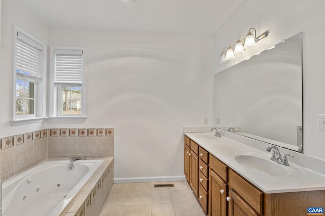 bathroom with tile patterned flooring, vanity, and tiled bath