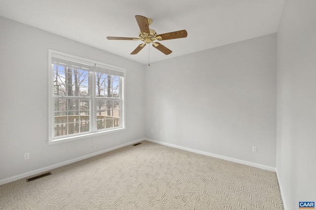 carpeted spare room with ceiling fan