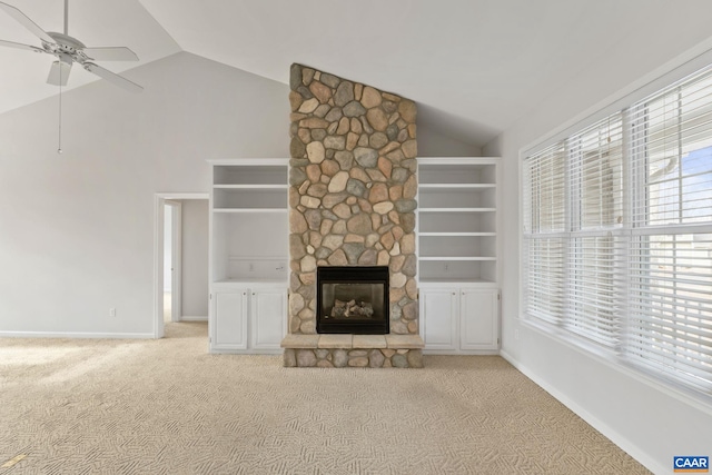 unfurnished living room with light carpet, a fireplace, ceiling fan, and vaulted ceiling