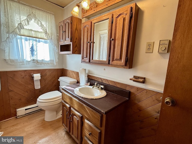 bathroom featuring toilet, vanity, wooden walls, and a baseboard radiator