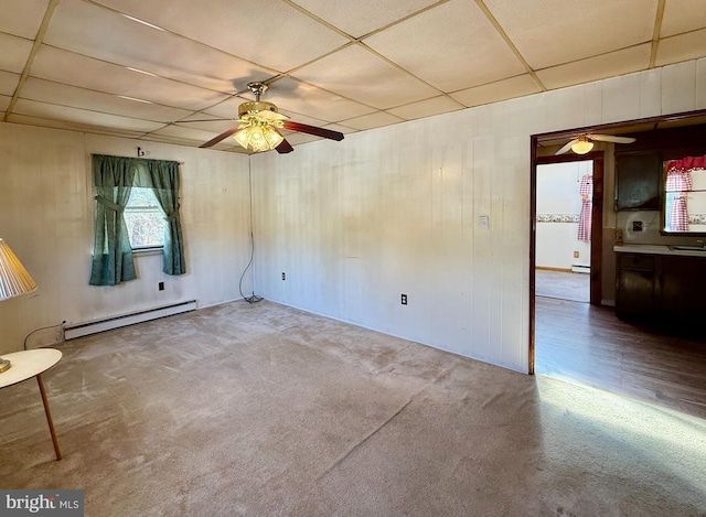 spare room featuring carpet, a baseboard heating unit, and a paneled ceiling