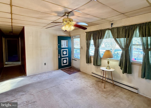 carpeted foyer entrance with a baseboard heating unit and ceiling fan