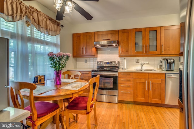 kitchen with ceiling fan, decorative backsplash, sink, light hardwood / wood-style flooring, and appliances with stainless steel finishes