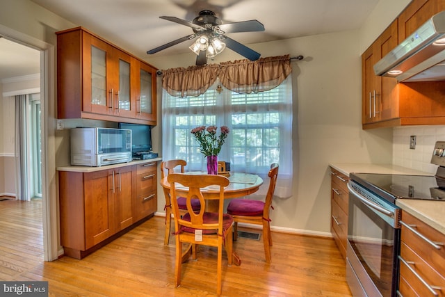 kitchen with ceiling fan, light wood-type flooring, electric range, and extractor fan