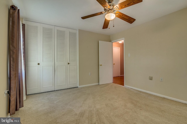 unfurnished bedroom with ceiling fan, a closet, and light carpet