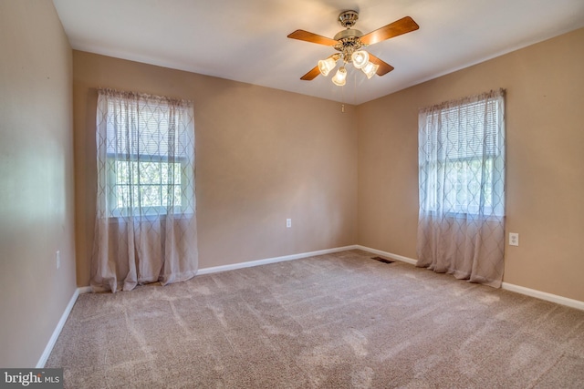 carpeted spare room with ceiling fan