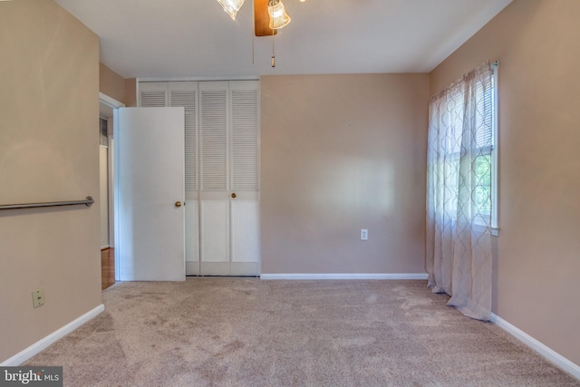 unfurnished bedroom with ceiling fan, a closet, and light carpet