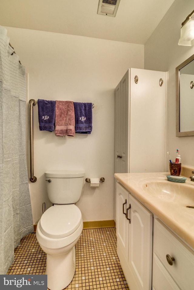 bathroom featuring toilet, vanity, and tile patterned floors