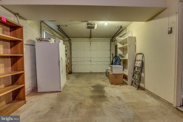 garage with a garage door opener and white refrigerator