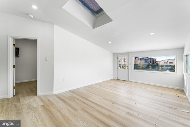 unfurnished living room with a skylight and light hardwood / wood-style flooring