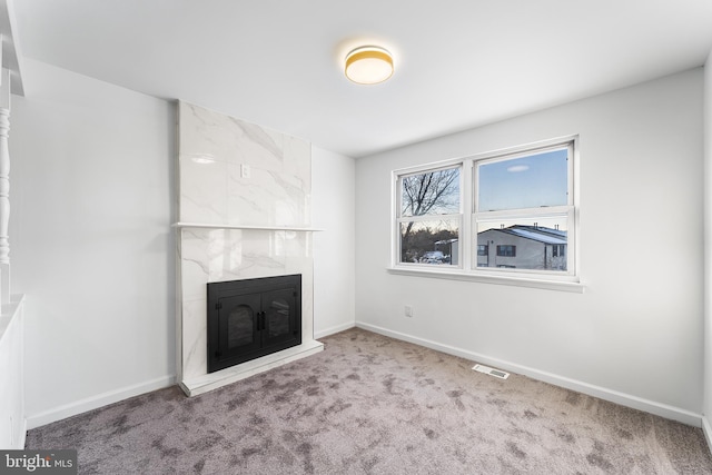 unfurnished living room featuring carpet flooring and a fireplace