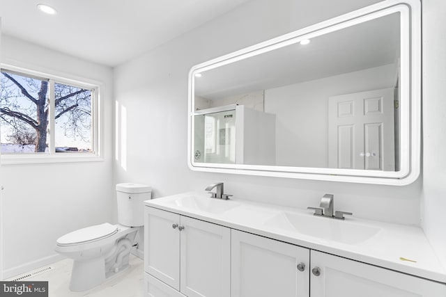 bathroom with a shower with shower door, vanity, and toilet