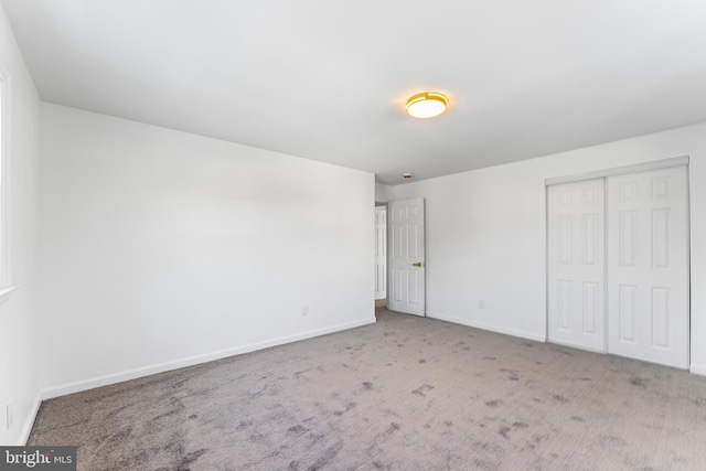 unfurnished bedroom with light carpet and a closet