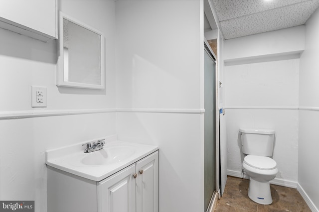 bathroom with toilet, vanity, and a shower with door