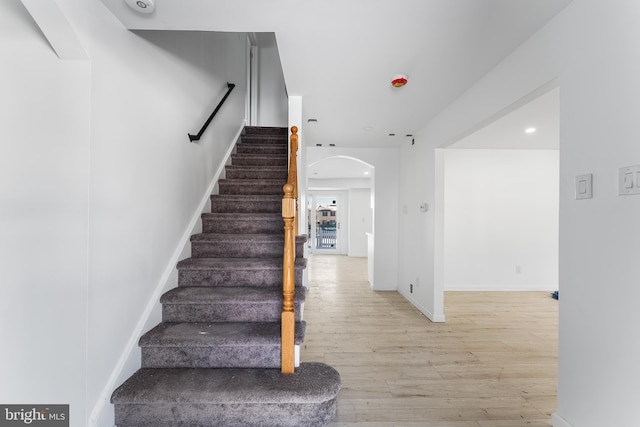 staircase with hardwood / wood-style floors