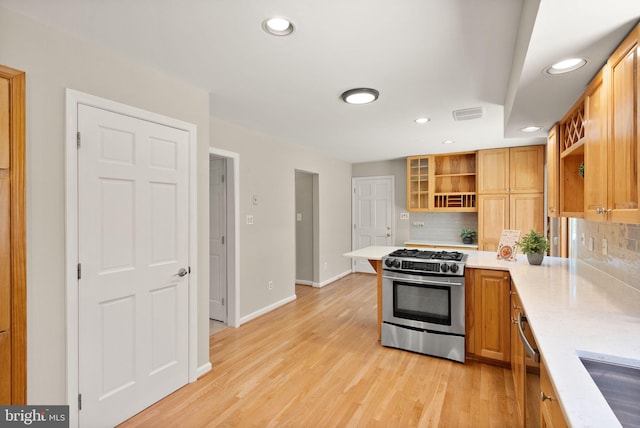 kitchen with open shelves, light wood finished floors, gas stove, and decorative backsplash