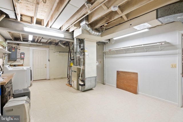 unfinished basement with electric panel, baseboards, tile patterned floors, heating unit, and washing machine and clothes dryer