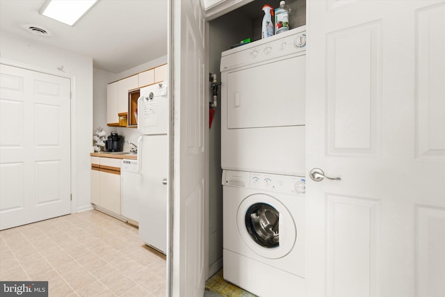 laundry area featuring stacked washer / drying machine