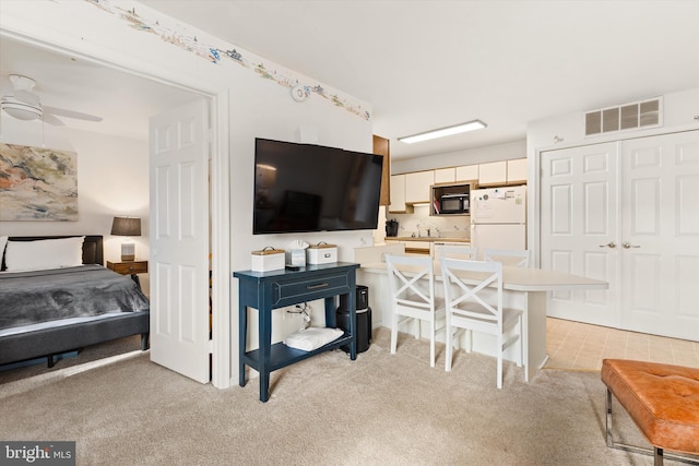 interior space featuring sink, light colored carpet, and ceiling fan