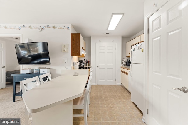 kitchen featuring a kitchen bar and white fridge