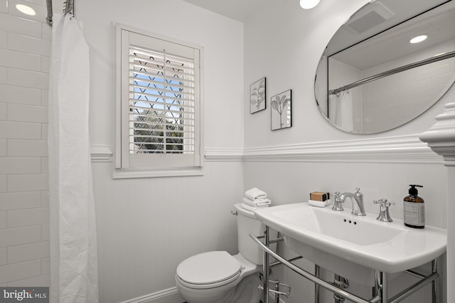 bathroom featuring sink, toilet, and a shower with shower curtain