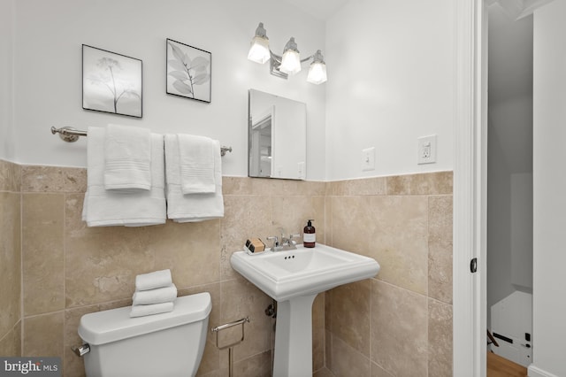 bathroom featuring tile walls, sink, and toilet