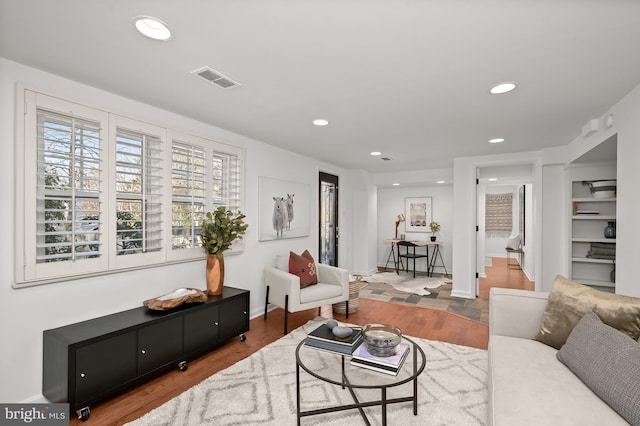 living room with hardwood / wood-style floors and built in features