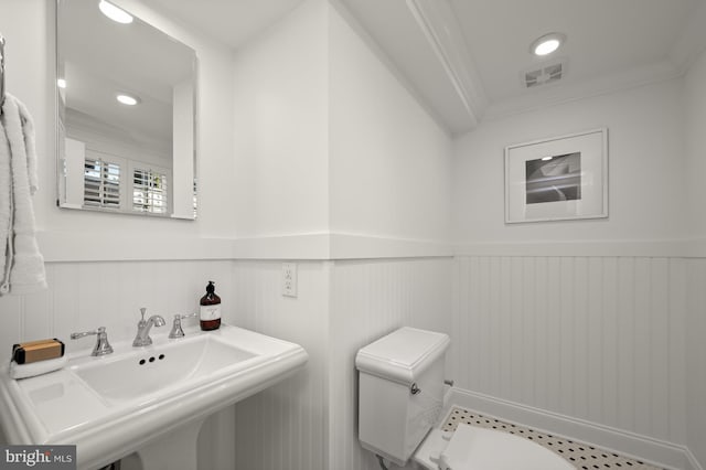 bathroom featuring ornamental molding, sink, and toilet