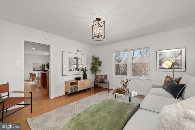 living room with crown molding, hardwood / wood-style flooring, and a chandelier