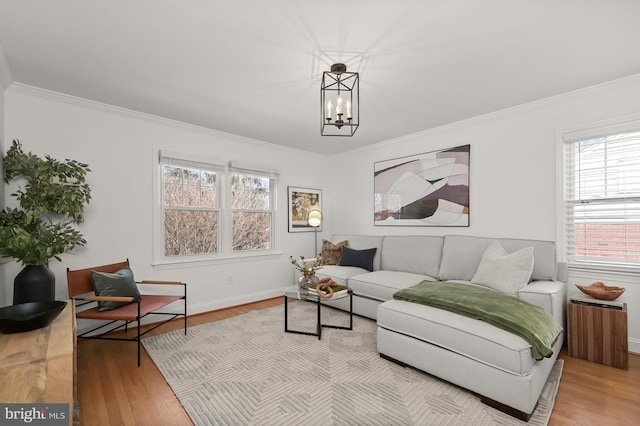 living room with ornamental molding, light hardwood / wood-style floors, and a notable chandelier