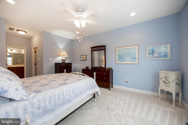 bedroom featuring ceiling fan, light colored carpet, and ensuite bathroom