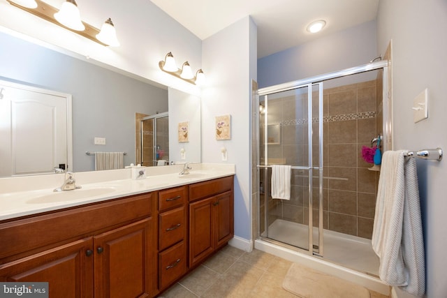 bathroom with a shower with shower door, tile patterned floors, and vanity