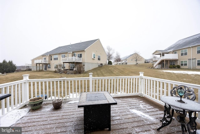 deck with an outdoor fire pit and a lawn