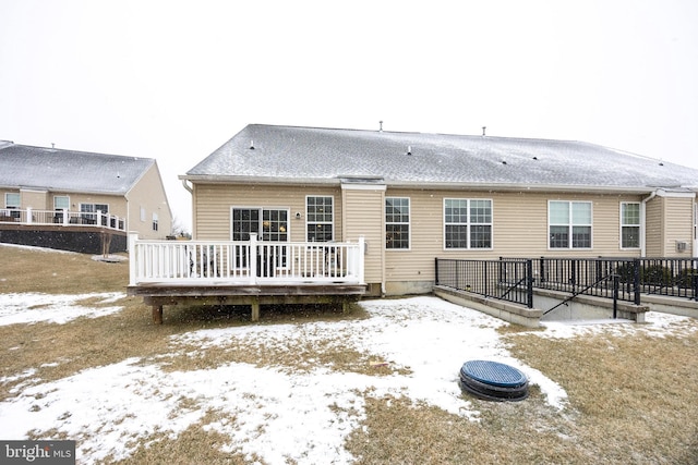 snow covered house with a deck