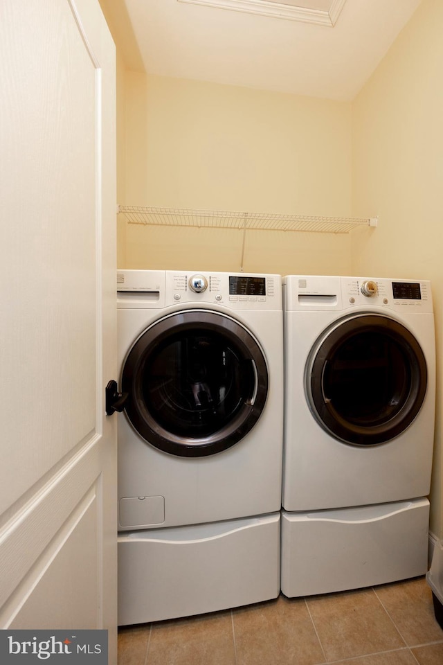 laundry room featuring separate washer and dryer and light tile patterned floors