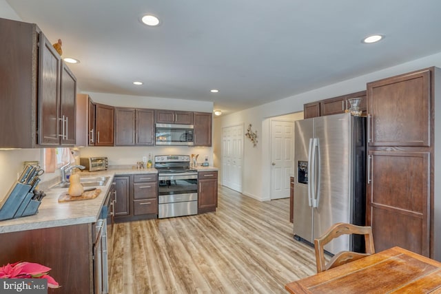 kitchen featuring light wood-type flooring, dark brown cabinets, sink, and stainless steel appliances