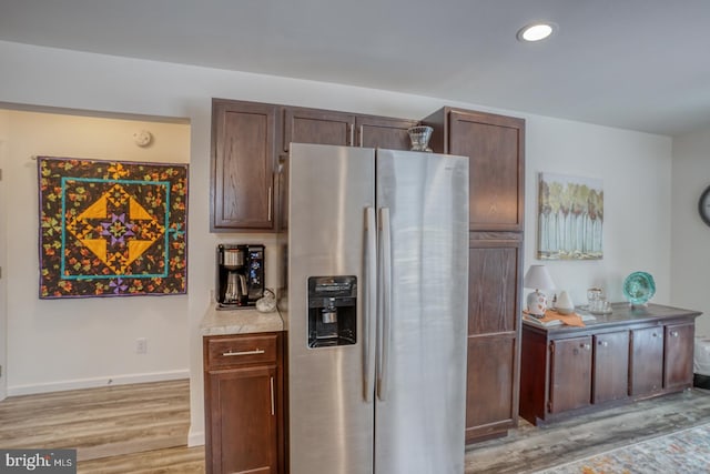 kitchen featuring stainless steel refrigerator with ice dispenser, light hardwood / wood-style flooring, and dark brown cabinetry