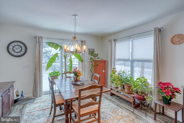 dining room featuring light wood-type flooring and an inviting chandelier