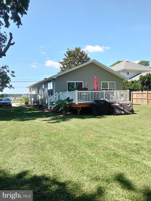 back of property with a lawn and a wooden deck