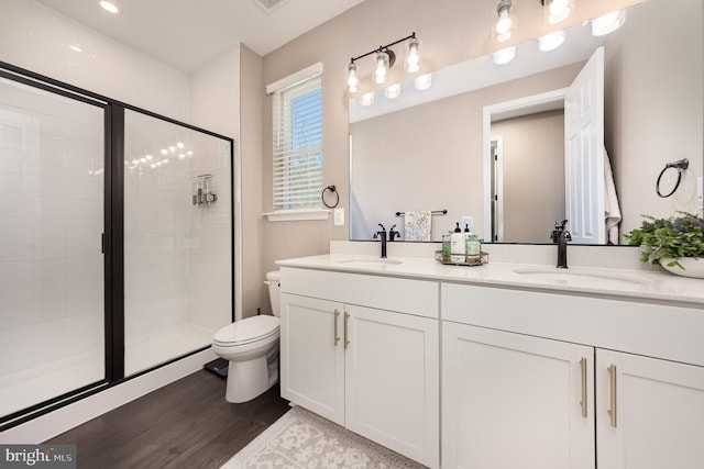 bathroom with wood-type flooring, toilet, an enclosed shower, and vanity