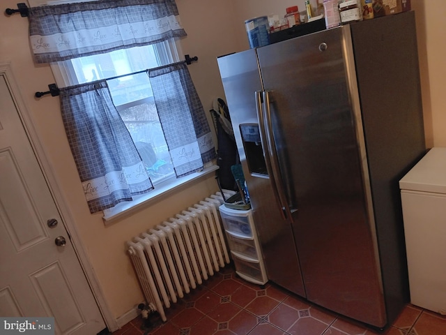 kitchen with stainless steel fridge, radiator, and washer / dryer