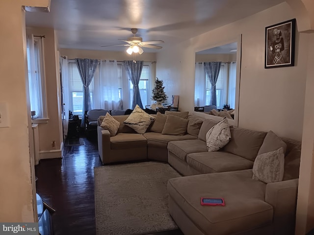 living room featuring dark wood-type flooring and ceiling fan