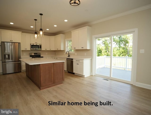 kitchen featuring a kitchen island, white cabinetry, hanging light fixtures, light hardwood / wood-style floors, and stainless steel appliances