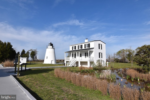 view of front of house with covered porch and a front lawn