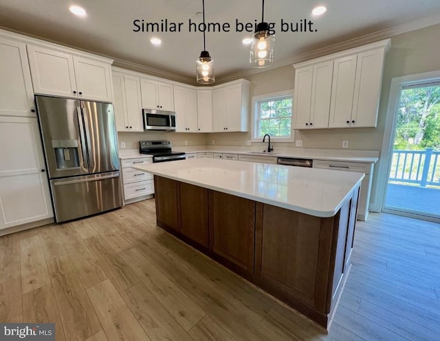 kitchen featuring a kitchen island, appliances with stainless steel finishes, pendant lighting, white cabinetry, and light wood-type flooring