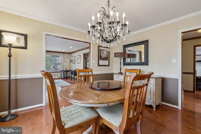 dining space featuring baseboards, hardwood / wood-style flooring, and crown molding